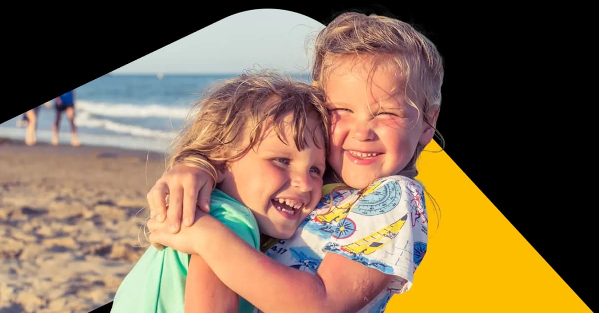 Two children hugging on a beach